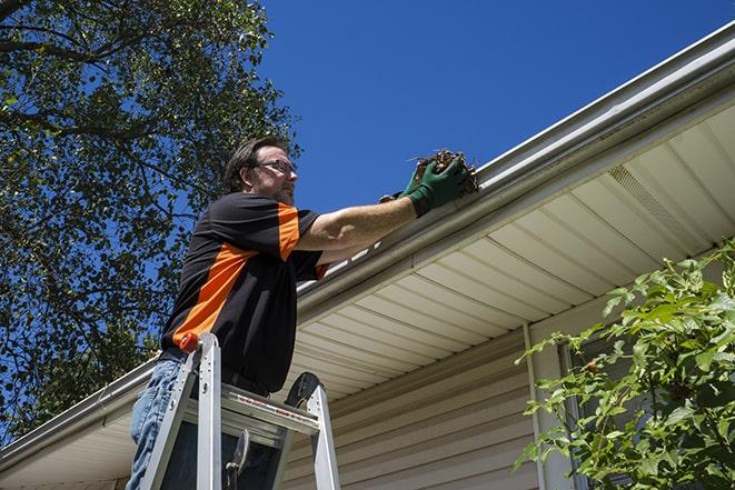 a gutter repair specialist working on a broken downspout in Batesburg-Leesville SC